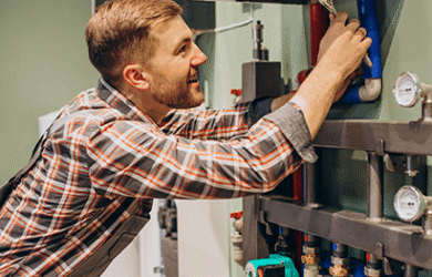 "Handyman repairing a dripping kitchen tap in a South London home"