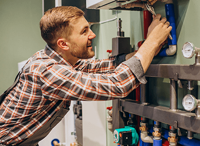 "Handyman repairing a dripping kitchen tap in a South London home"